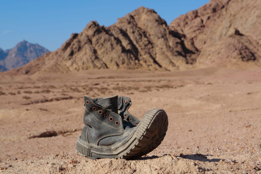 Old black boot in desert